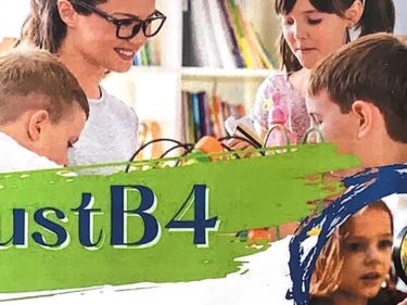 Three small children learning with a teacher.