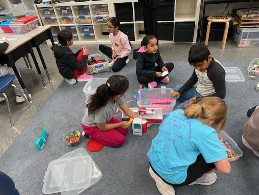 Students playing at a carpet.